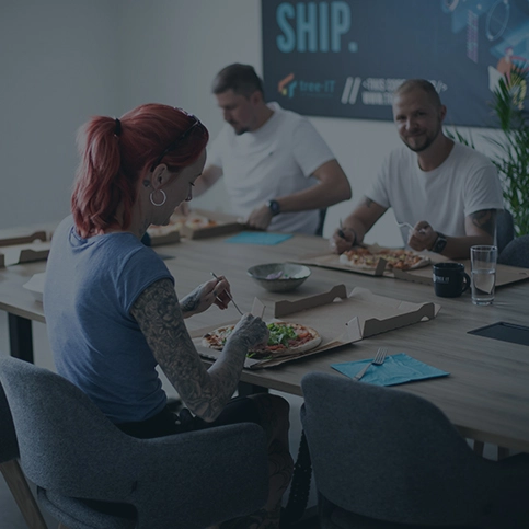 Bild von Menschen, die Pizza im Besprechungsraum essen