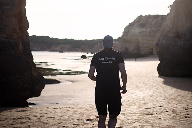 Bild eines Mannes beim Joggen am Strand mit einem tree-IT T-Shirt